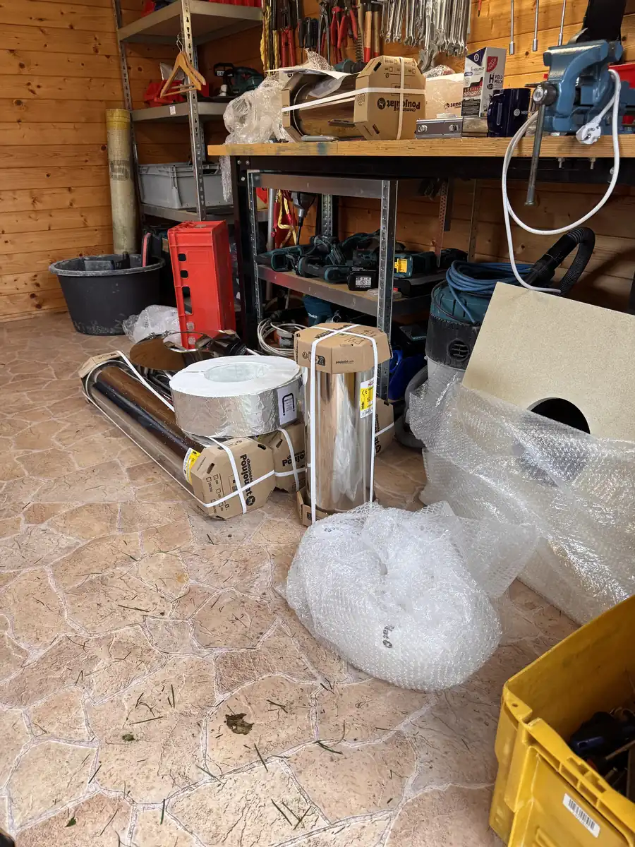 Ofen und Schornsteinmaterial liegen in der Gartenlaube f&uuml;r den Einbau bereit